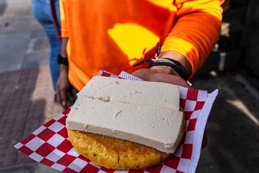 Een persoon houdt een sandwich vast, verpakt in een ruitjeswikkelpapier. 3