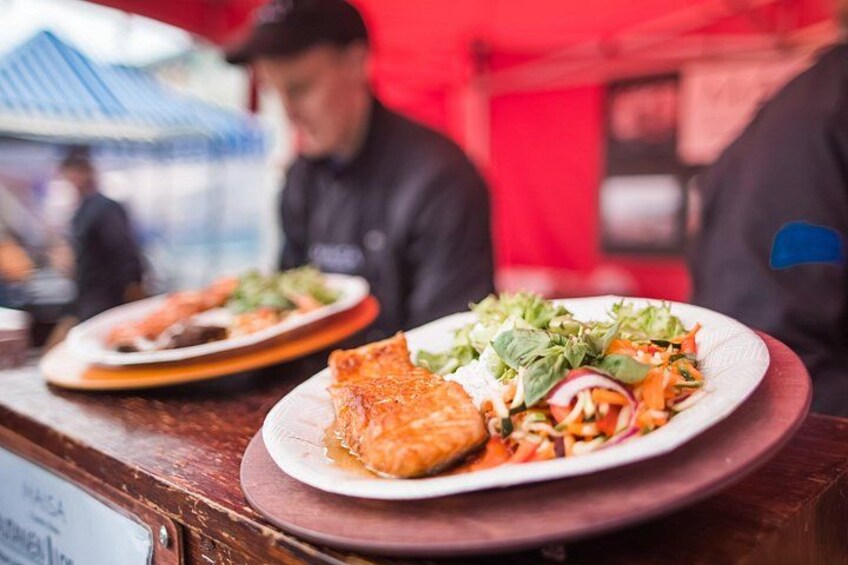 A restaurant counter with plates of food, including a salad and a piece of meat. 2