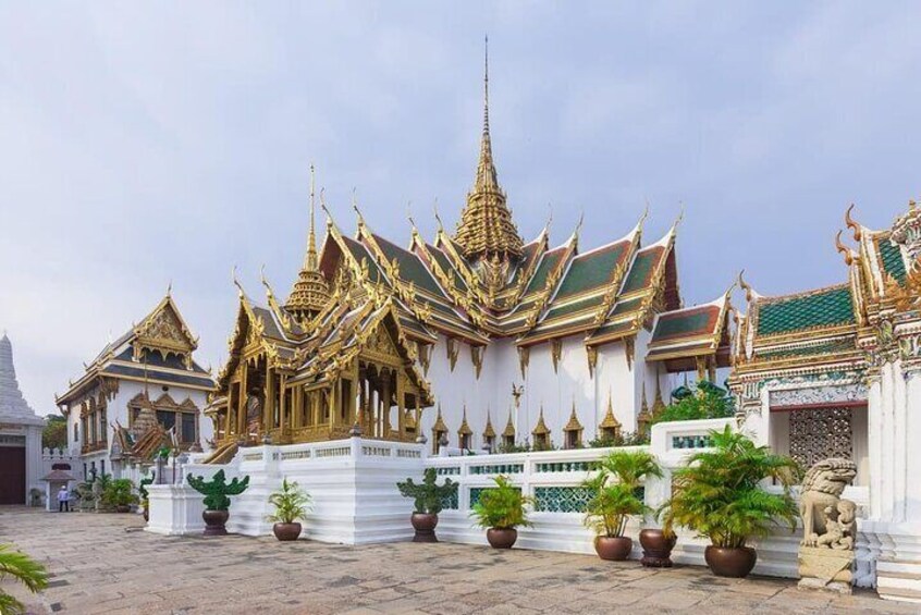 A traditional Thai temple with ornate golden roofs and white walls. 5