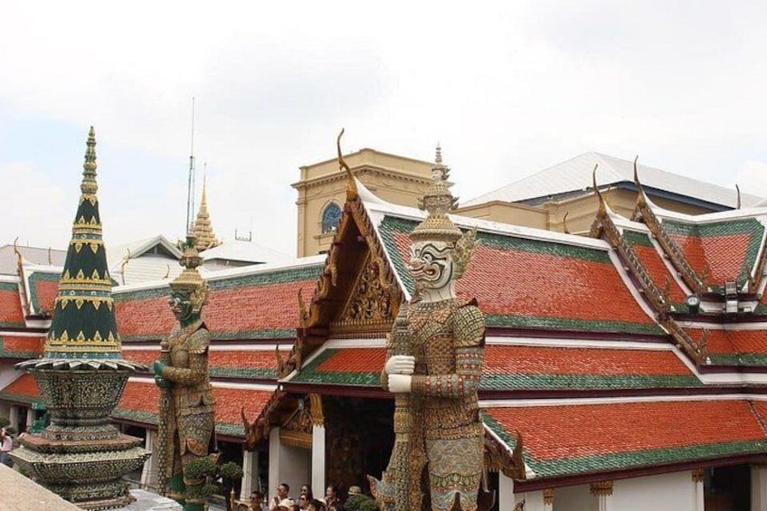 A traditional Thai temple with ornate decorations, including a large golden statue and tiered roofs. 3