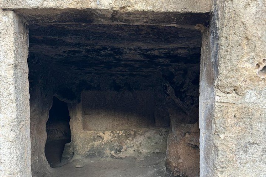 A cave entrance with rough stone walls and a narrow passageway. 4