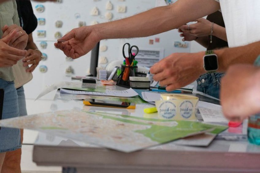 A group of people engaged in a discussion around a table with maps and documents. 5