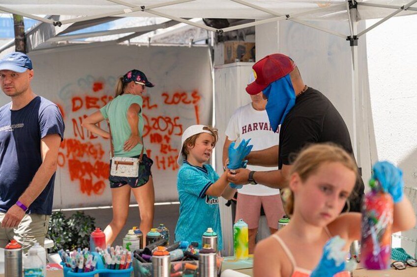 People at an art booth with paint supplies. 5