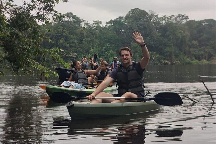 Una persona en un bote verde navega por un río tranquilo rodeado de exuberante vegetación. 1