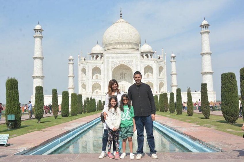 The Taj Mahal with four people standing in front of it. 2