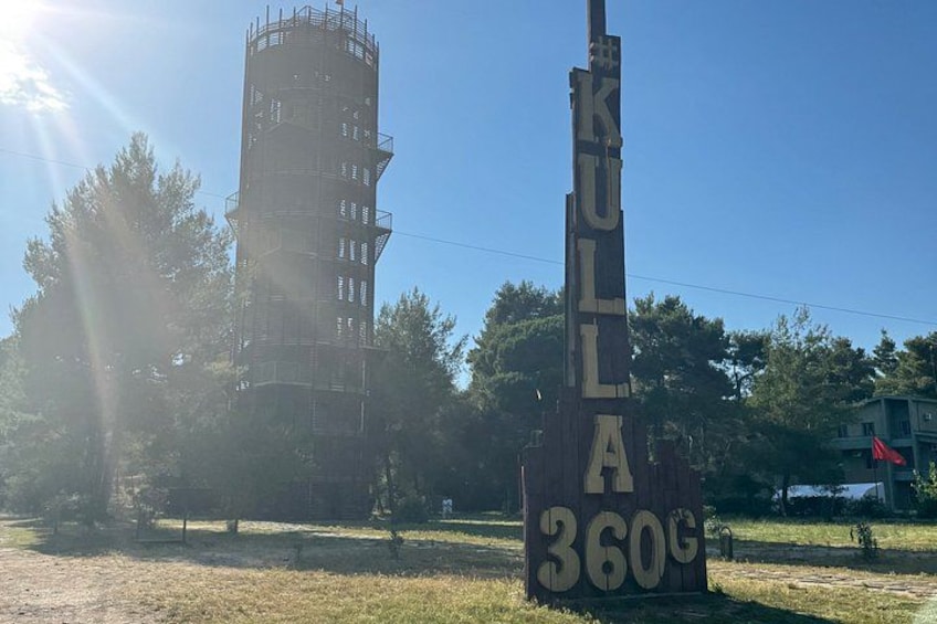 Ein hoher Turm mit Gerüst, ein hölzernes Schild mit der Aufschrift 'KULLA 360°' und ein strahlend blauer Himmel. 5
