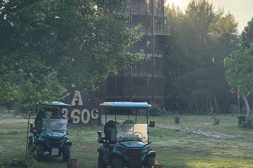 Zwei Geländefahrzeuge stehen auf einer Wiese, im Hintergrund ein großes Schild. 1