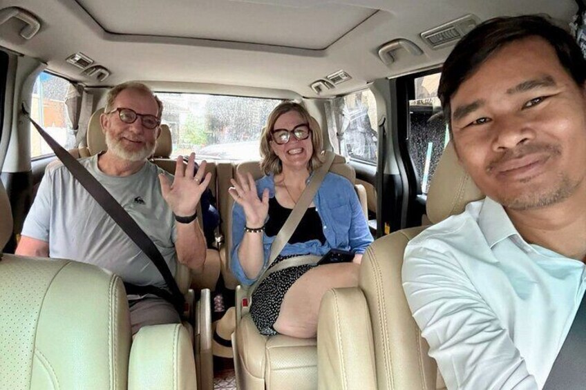 Three people in a car, with one person in the driver's seat and two others in the back. 5