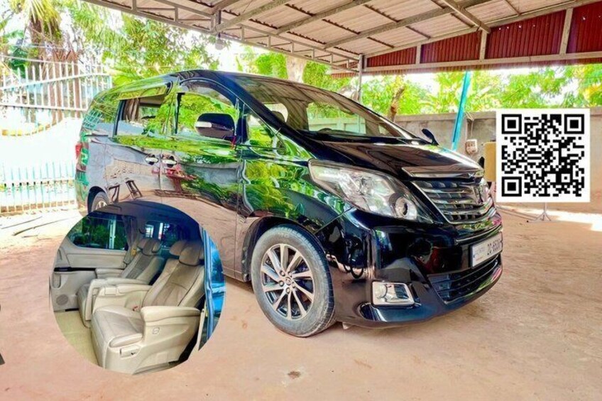 A black van parked under a covered area with a QR code on the ground. 4