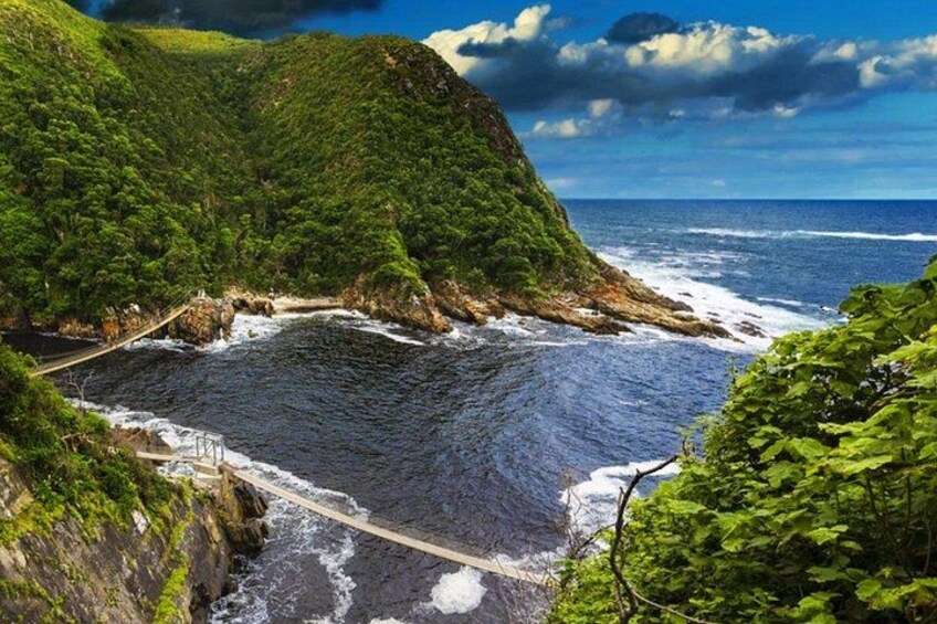 A coastal landscape with a bridge, cliffs, and ocean. 2