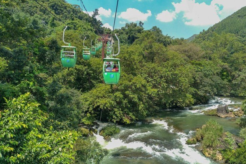 A cable car system over a river surrounded by dense forest. 1