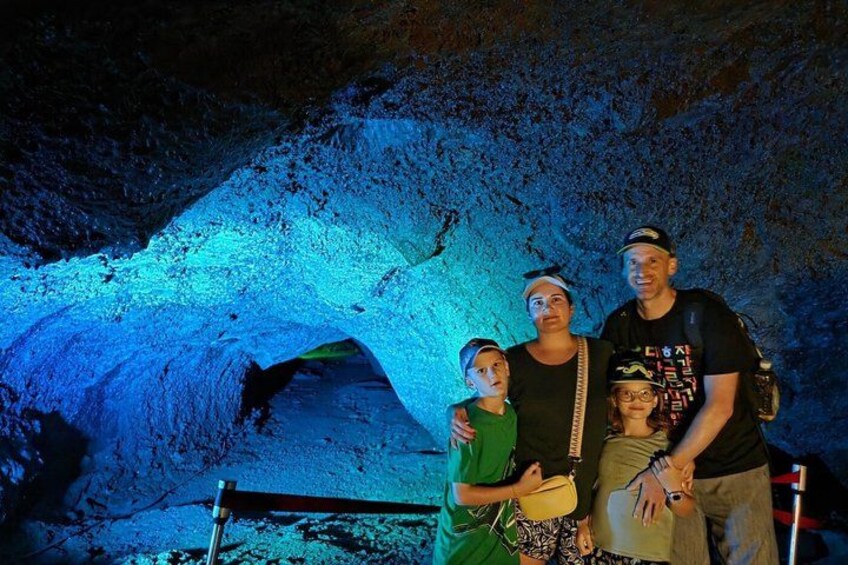 A family posing in front of a cave illuminated by blue lighting. 3
