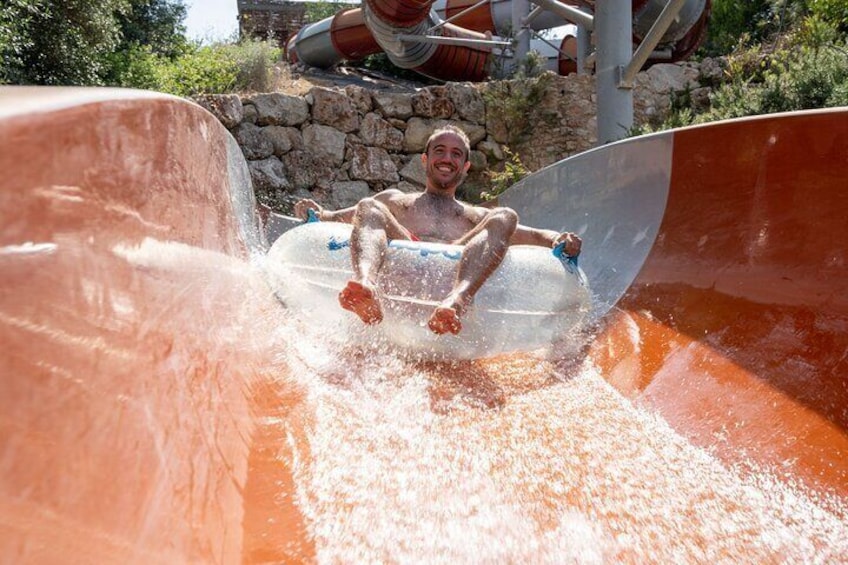 A person sliding down a water slide in a tube. 2