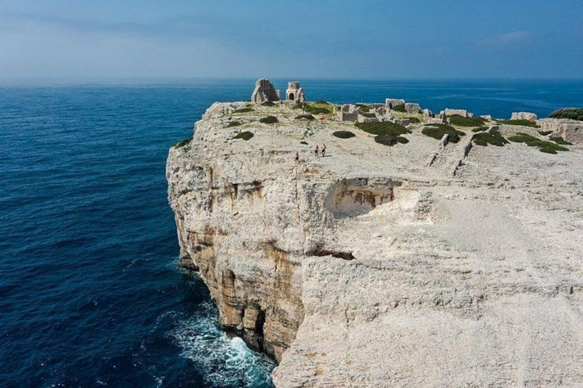 A coastal cliff with ruins and a clear view of the sea. 4