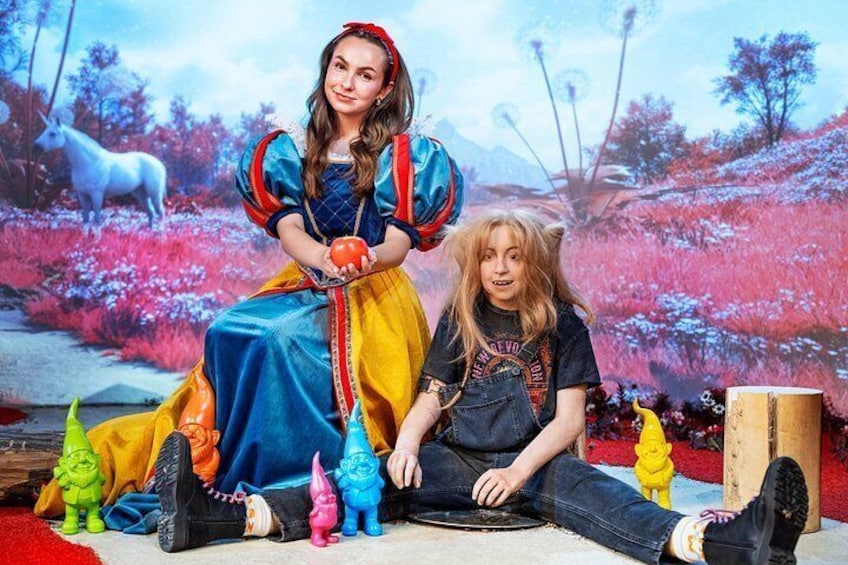 A person in a blue dress with a red headband, sitting on the floor with a child. 3