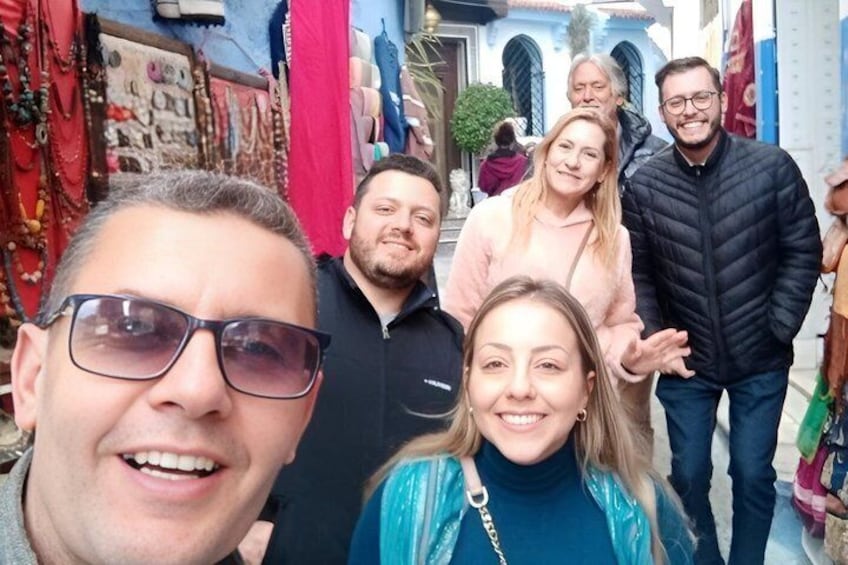 A group of people in a narrow street with shops on either side. 4