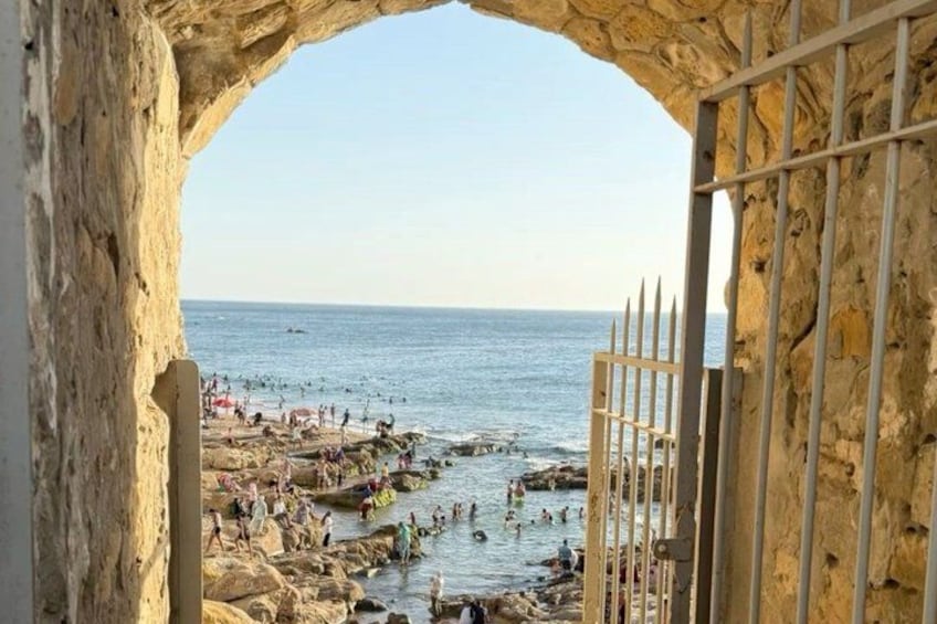 A rocky beach with people swimming and sunbathing. 4
