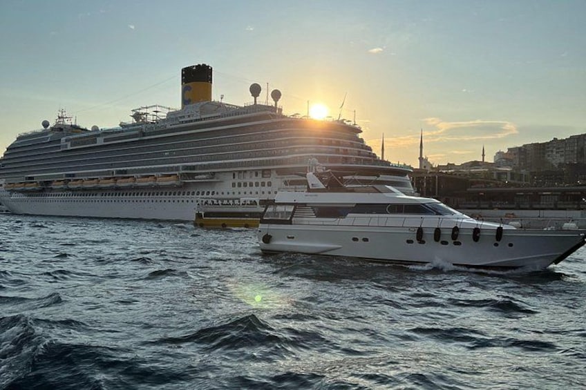 A cruise ship docked at a port with a sunset in the background. 3