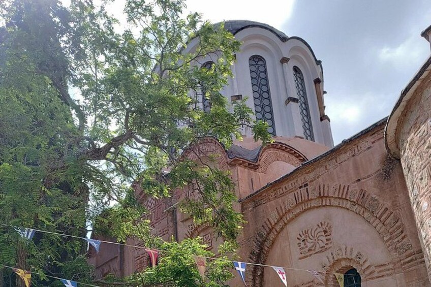 Een kerk met een koepel en gebogen ramen, omringd door bomen. 3