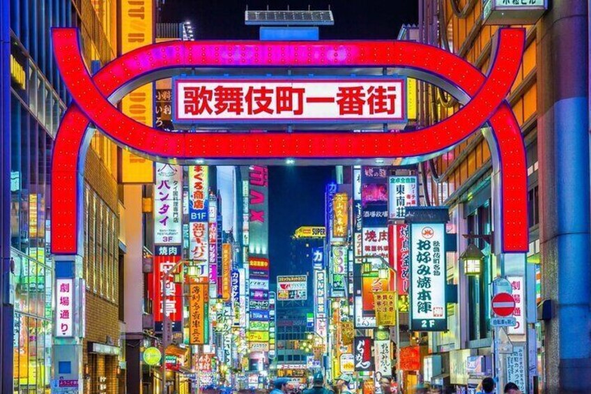 A brightly lit street with neon signs and advertisements in a foreign language. 2