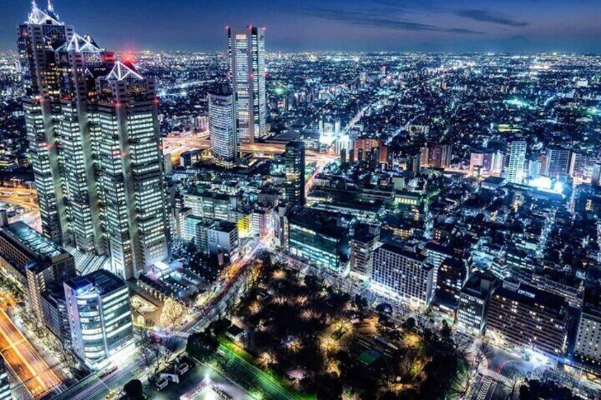 A nighttime cityscape with illuminated skyscrapers and a dense urban layout. 5