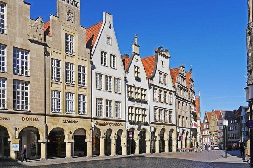 En historisk europæisk gade med traditionel arkitektur, blandt andet buede vinduer og brostensbelagt vej. 2
