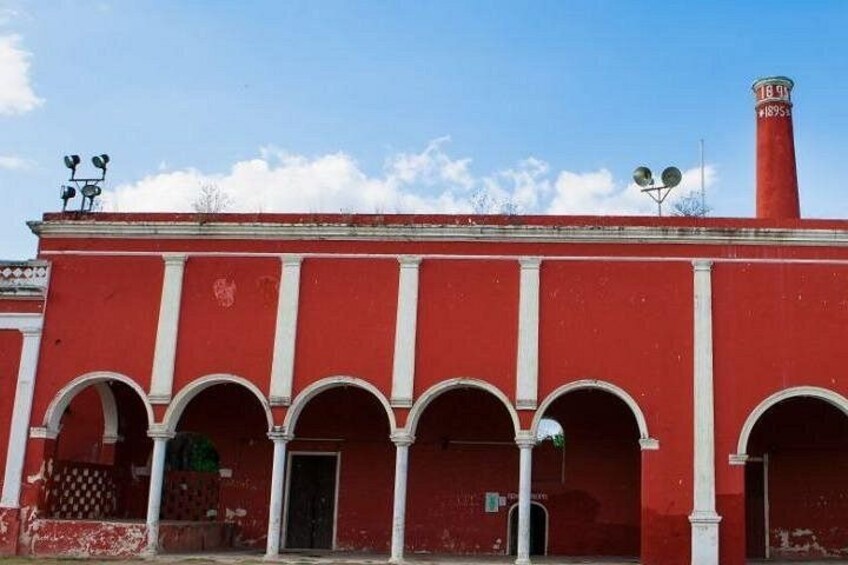 A red building with white columns and a chimney. 3