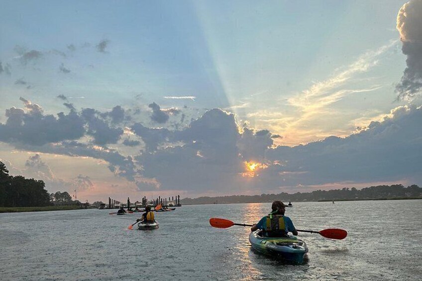 Roeiers op een kalm wateroppervlak tijdens de zonsondergang. 5