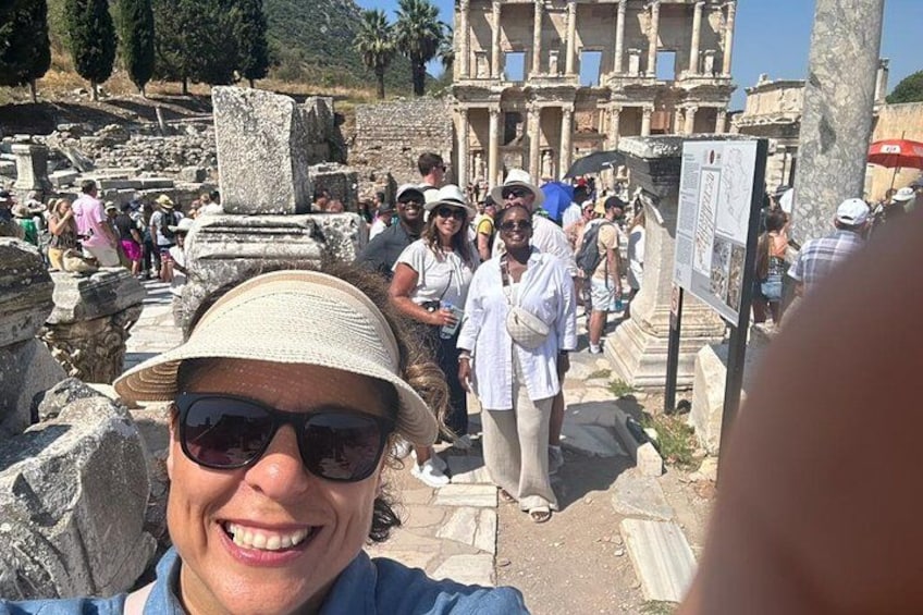 An ancient ruin with stone columns and a crowd of tourists. 5