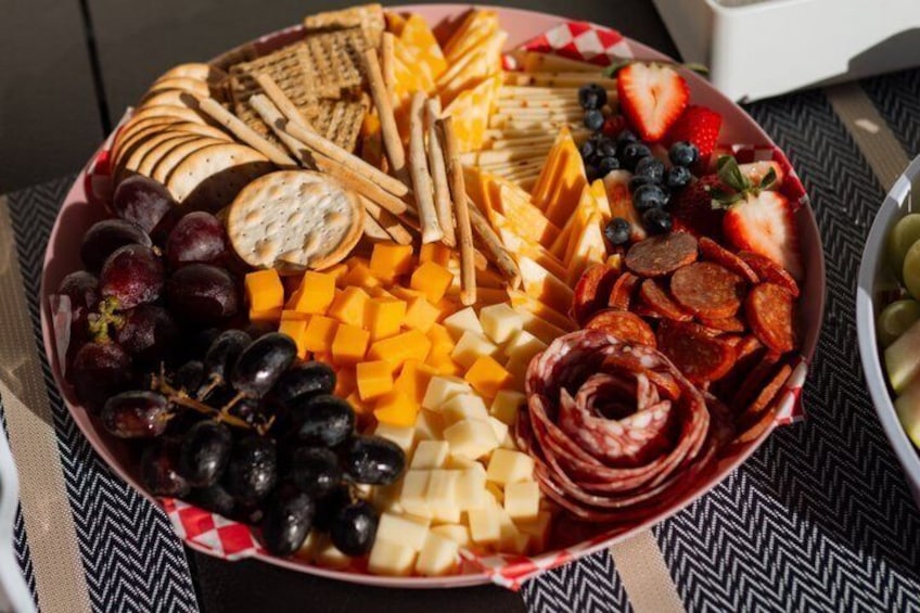 A charcuterie board with various cheeses, crackers, fruits, and meats. 4