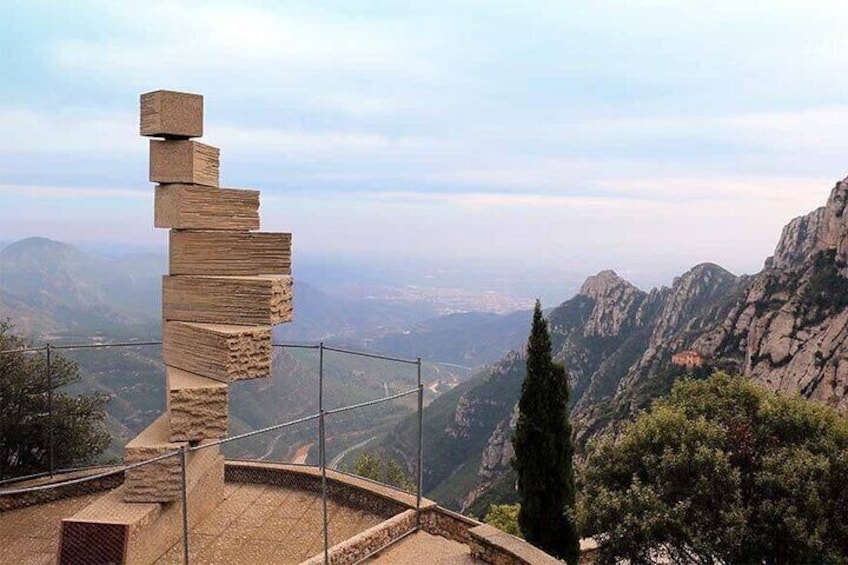 A stone sculpture of stacked blocks on a mountain overlook. 1