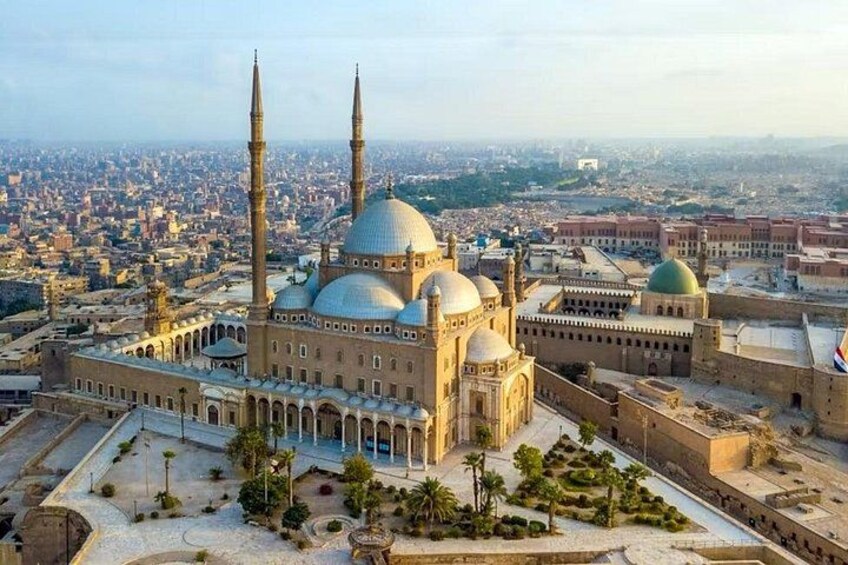 A large mosque with two minarets and multiple domes, surrounded by a cityscape. 3