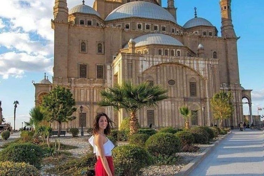 A historic building with domes and minarets, surrounded by greenery and a paved walkway. 5