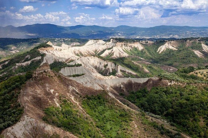 A rugged landscape with layered hills and sparse vegetation. 5
