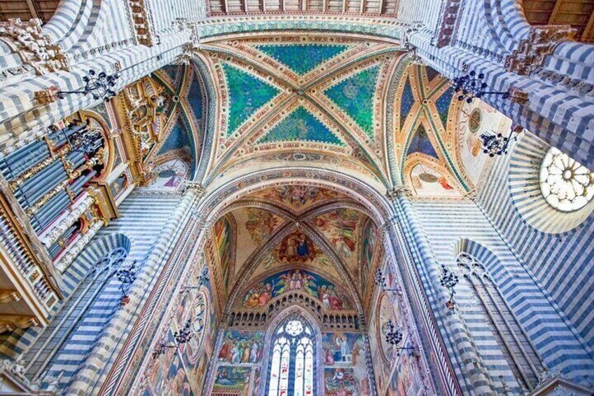 Interior ornamentado de una catedral, con un techo detallado, vidrieras de colores y detalles arquitectónicos intrincados. 4