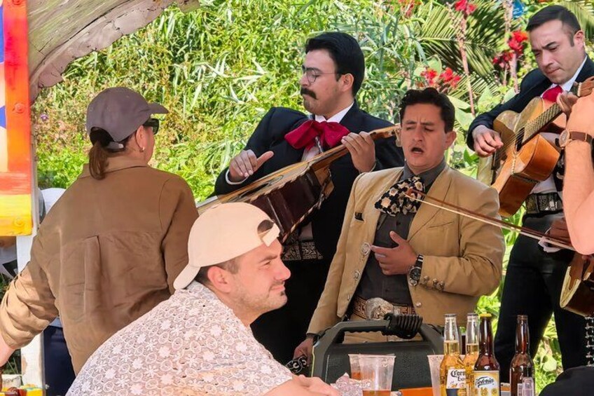 Een groep muzikanten treedt buiten aan, met een gitarist en een violist. 3