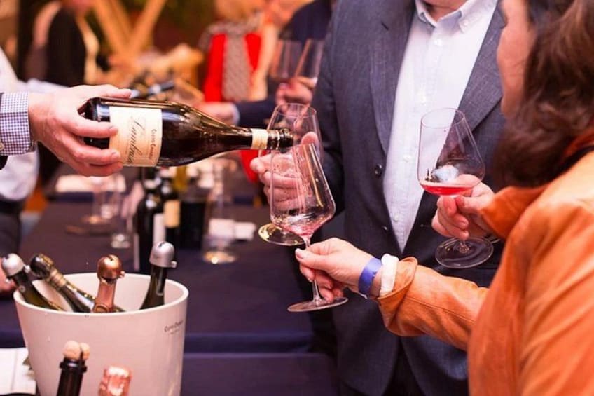 A person pouring wine into a glass. 1