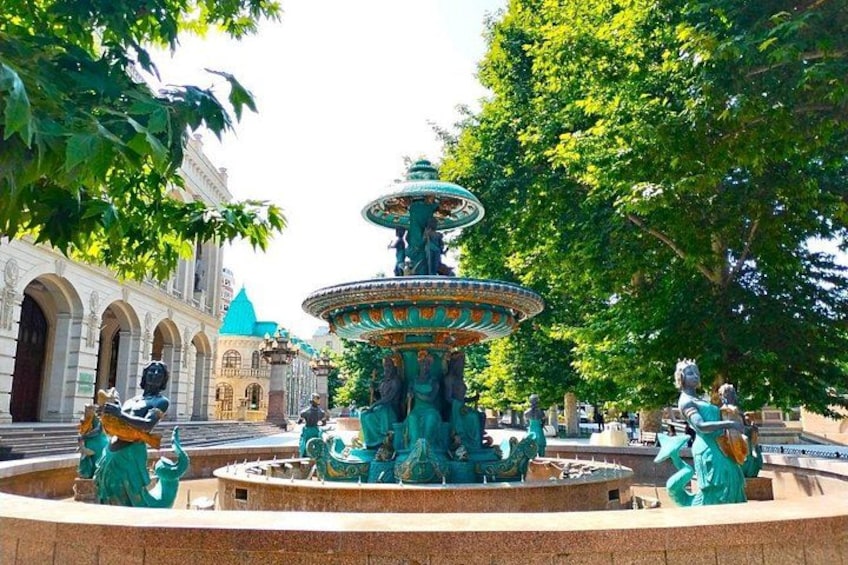 A large, ornate fountain with statues in a park. 1