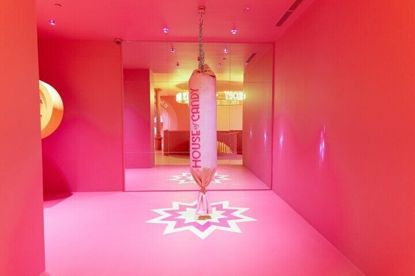 A pink-themed hallway with a punching bag labeled "HOUSE OF CANDY" and a star-shaped floor design. 3