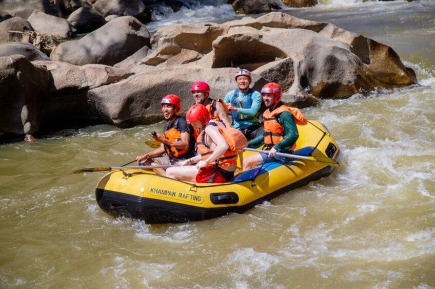 A group of people rafting on a yellow raft with 'KHAMPAN RAFTING' written on it. 5