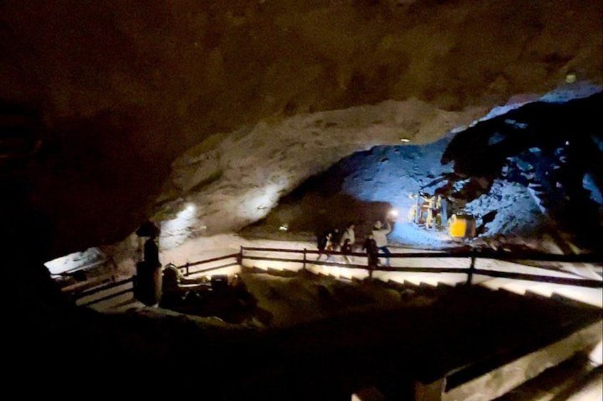 A cave interior with a staircase leading to a platform. 1