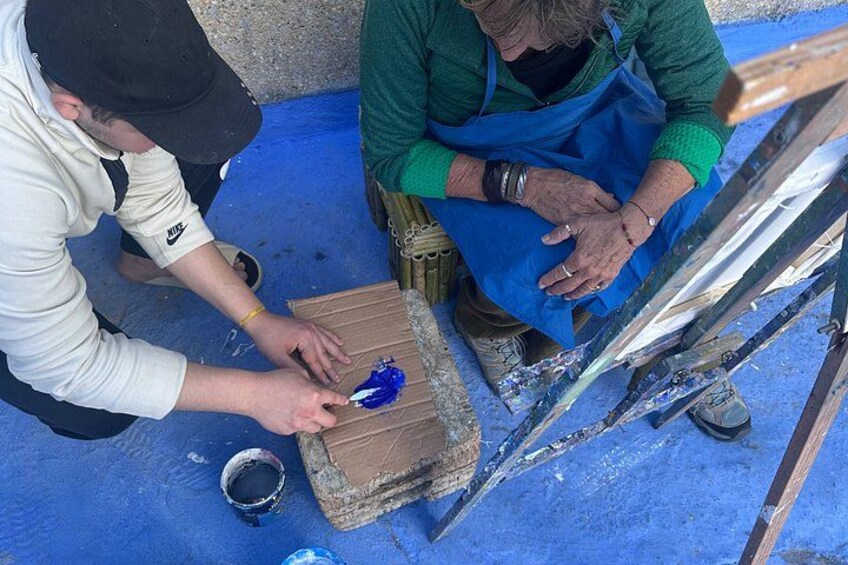 Two people painting a wooden surface with blue paint. 5