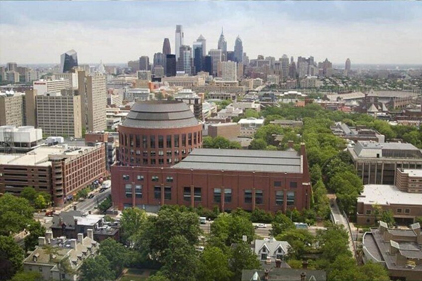 A cityscape with a prominent red building with a dome, surrounded by other buildings and greenery. 2