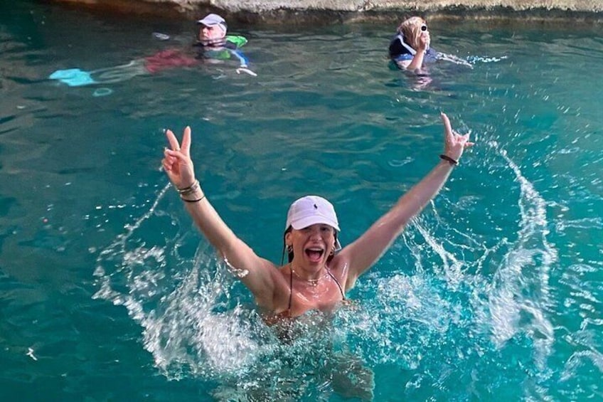 A person swimming in a pool with arms raised. 1