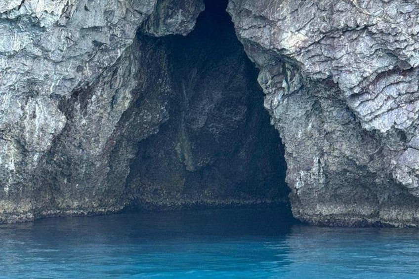 A natural rock formation with a cave entrance. 3