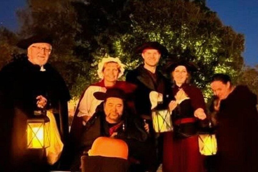 Eine Gruppe von Menschen in historischen Kostümen steht nachts draußen. 3