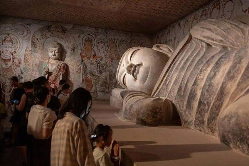 Et museumsinteriør med store statuer og detaljerede vægmalerier. 5
