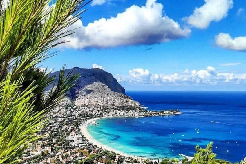 A coastal town with a mountain, turquoise waters, and clear skies. 4