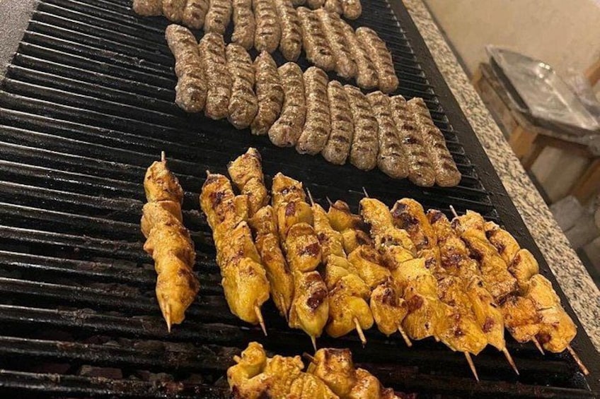 Een barbecue met verschillende vleessoorten die worden bereid. 5