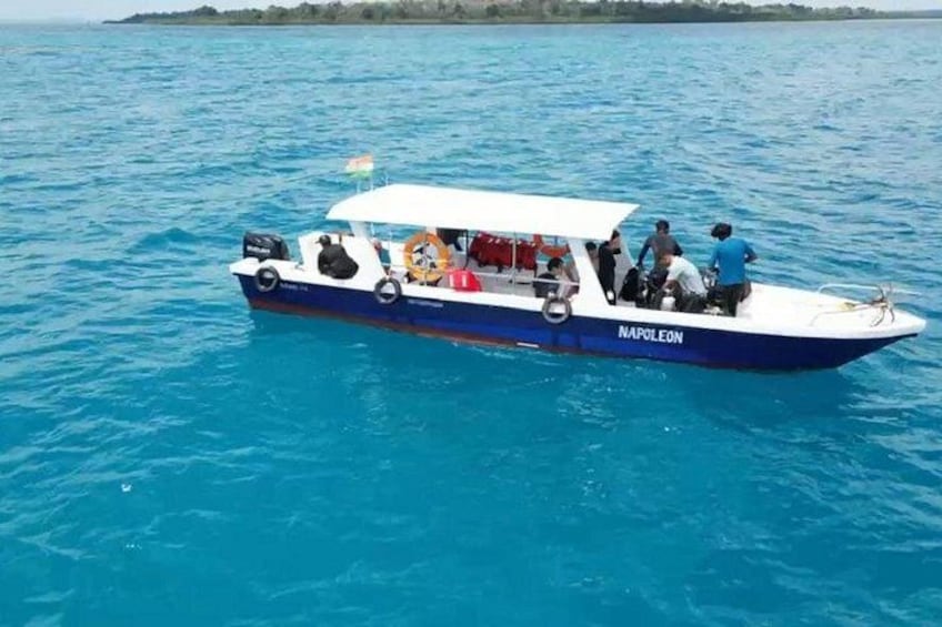 A boat named 'NAPOLEON' on a body of water with people on board. 2